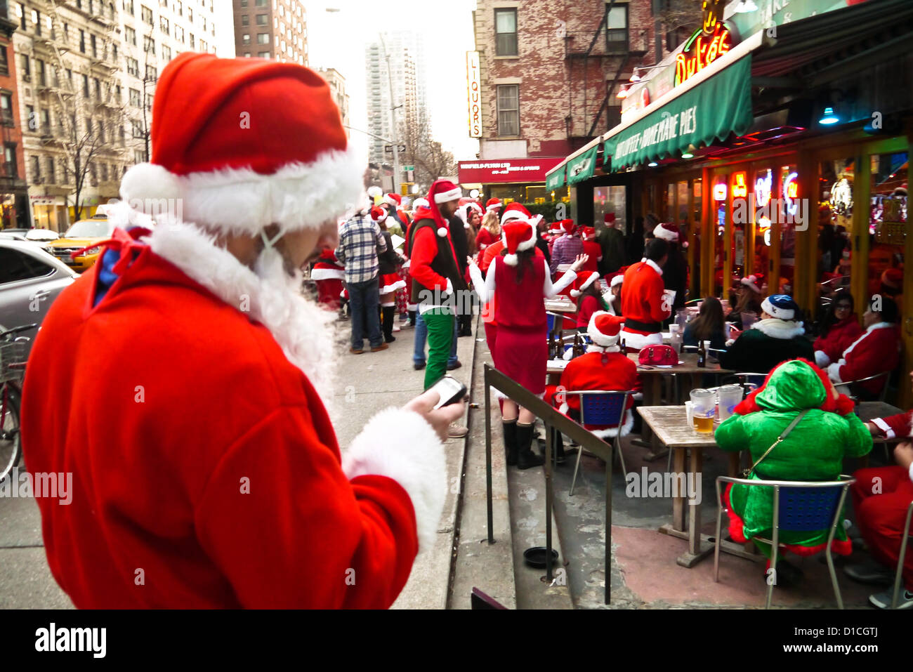 NEW YORK, NY - 15 dicembre: buontemponi vestiti da Babbo Natale di attendere in linea per raggiungere in barre sulla terza avenue durante l'annuale evento SantaCon Dicembre 15, 2012 in New York City. (Foto di Donald Bowers) Foto Stock