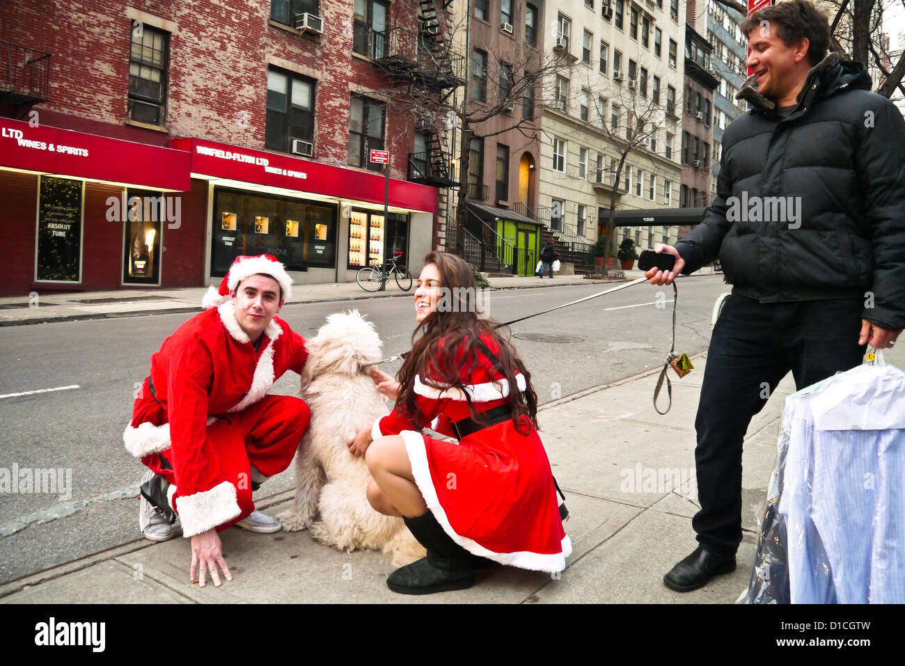 NEW YORK, NY - 15 dicembre: buontemponi vestiti da Babbo Natale di ottenere le loro foto scattata con un cane sulla strada durante l'annuale evento SantaCon Dicembre 15, 2012 in New York City. (Foto di Donald Bowers) Foto Stock