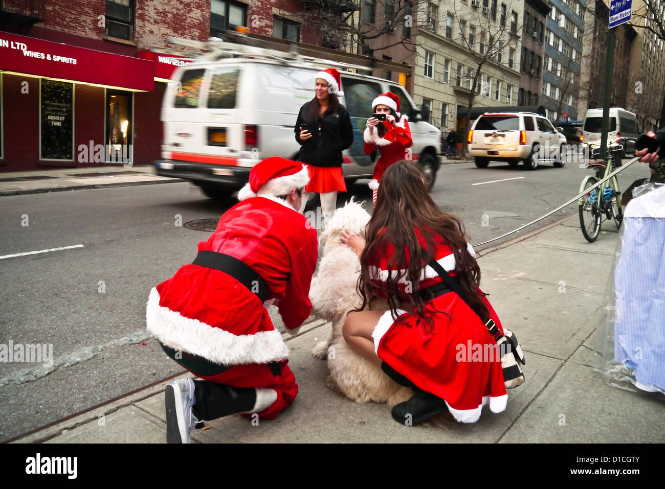 NEW YORK, NY - 15 dicembre: buontemponi vestiti da Babbo Natale di ottenere le loro foto scattata con un cane sulla strada durante l'annuale evento SantaCon Dicembre 15, 2012 in New York City. (Foto di Donald Bowers) Foto Stock