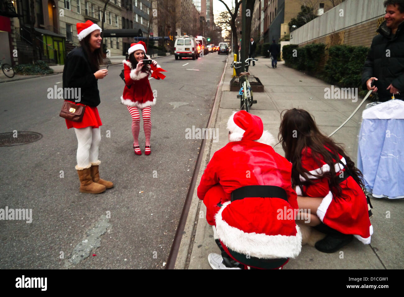 NEW YORK, NY - 15 dicembre: buontemponi vestiti da Babbo Natale di ottenere le loro foto scattata con un cane sulla strada durante l'annuale evento SantaCon Dicembre 15, 2012 in New York City. (Foto di Donald Bowers) Foto Stock