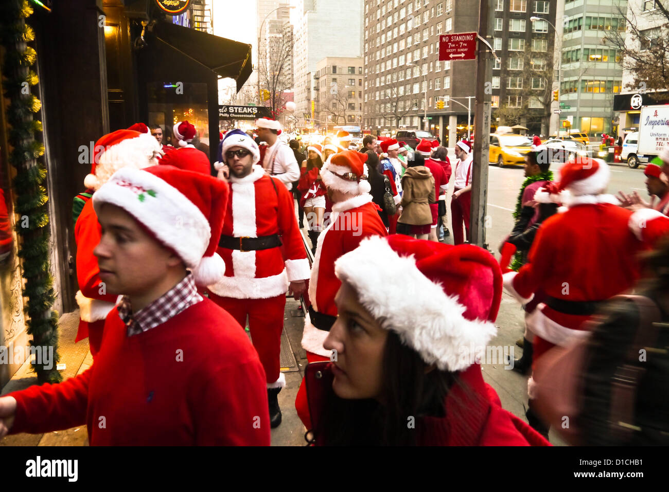 NEW YORK, NY - 15 dicembre: buontemponi vestiti da Babbo Natale di attendere in linea per raggiungere in barre sulla terza avenue durante l'annuale evento SantaCon Dicembre 15, 2012 in New York City. (Foto di Donald Bowers) Foto Stock