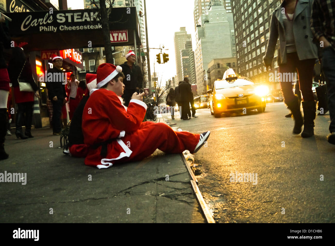 NEW YORK, NY - 15 dicembre: buontemponi vestiti da Babbo Natale sedersi sulla strada a riposo durante l'annuale evento SantaCon Dicembre 15, 2012 in New York City. (Foto di Donald Bowers) Foto Stock