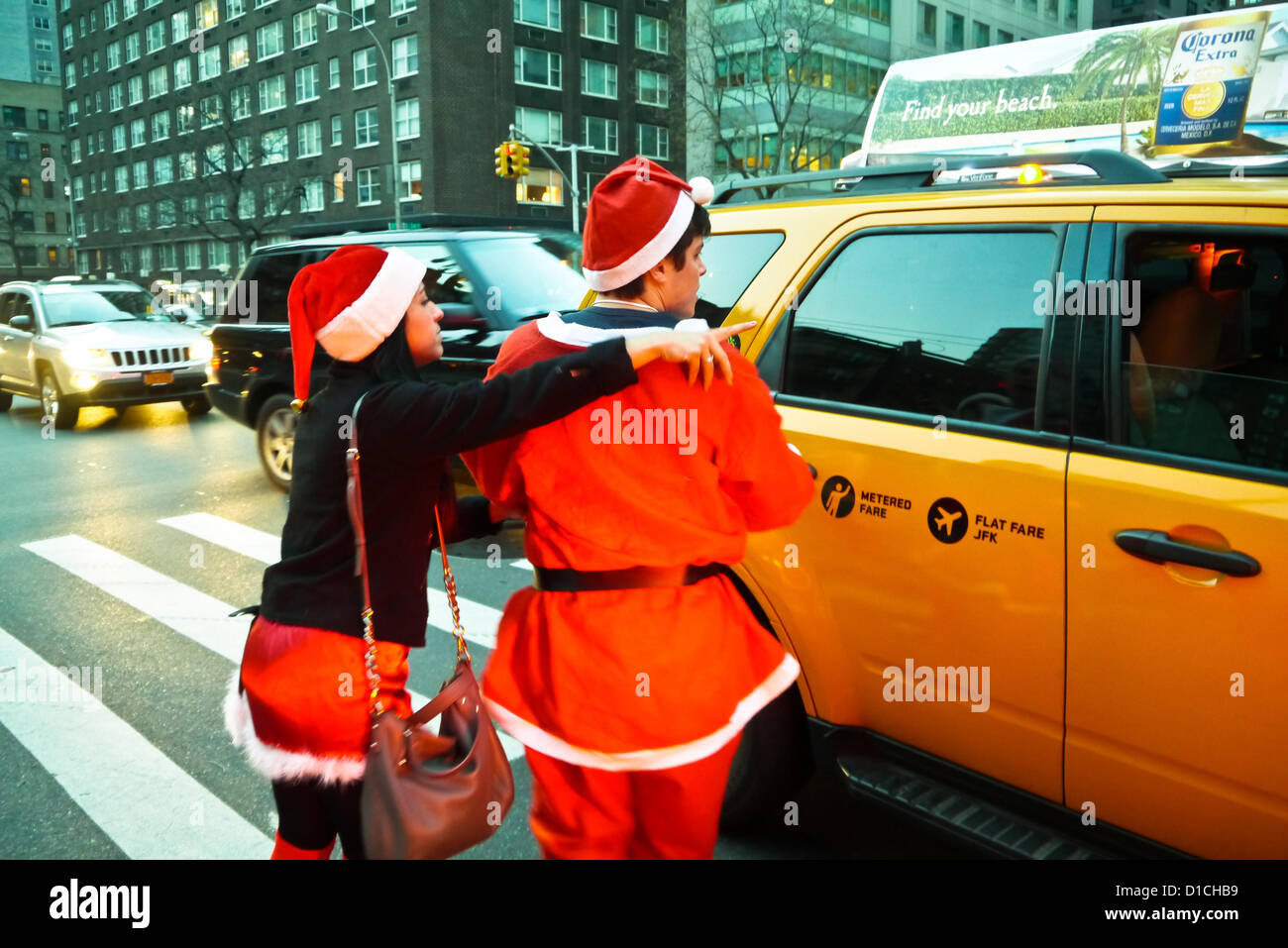 NEW YORK, NY - 15 dicembre: buontemponi vestiti da Babbo Natale provare a grandine una cabina durante l'annuale evento SantaCon Dicembre 15, 2012 in New York City. (Foto di Donald Bowers) Foto Stock