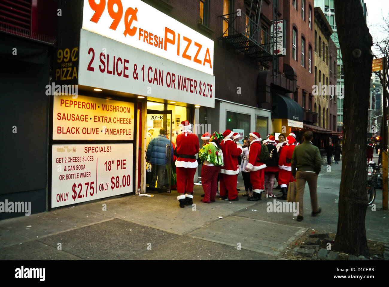 NEW YORK, NY - 15 dicembre: buontemponi vestiti da Babbo Natale di attendere in linea per 99 cent Pizza durante l'annuale evento SantaCon Dicembre 15, 2012 in New York City. (Foto di Donald Bowers) Foto Stock