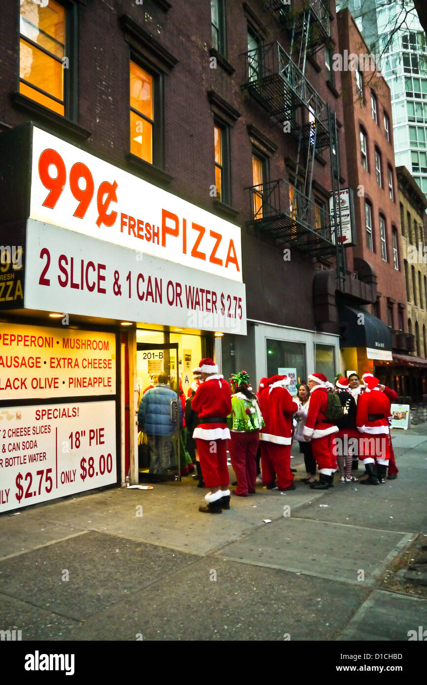 NEW YORK, NY - 15 dicembre: buontemponi vestiti da Babbo Natale di attendere in linea per 99 cent Pizza durante l'annuale evento SantaCon Dicembre 15, 2012 in New York City. (Foto di Donald Bowers) Foto Stock