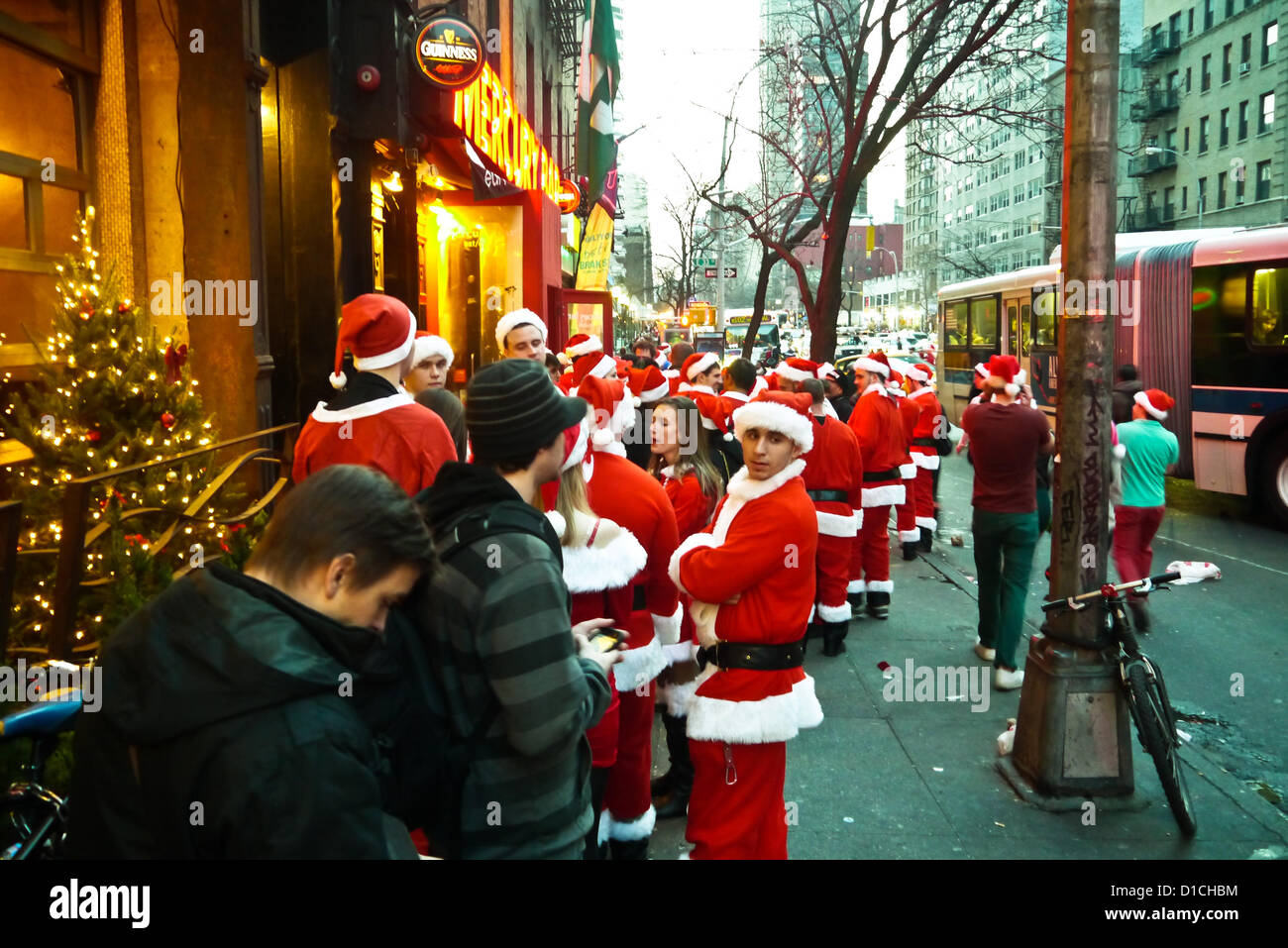 NEW YORK, NY - 15 dicembre: buontemponi vestiti da Babbo Natale di attendere in linea per raggiungere in barre sulla terza avenue durante l'annuale evento SantaCon Dicembre 15, 2012 in New York City. (Foto di Donald Bowers) Foto Stock