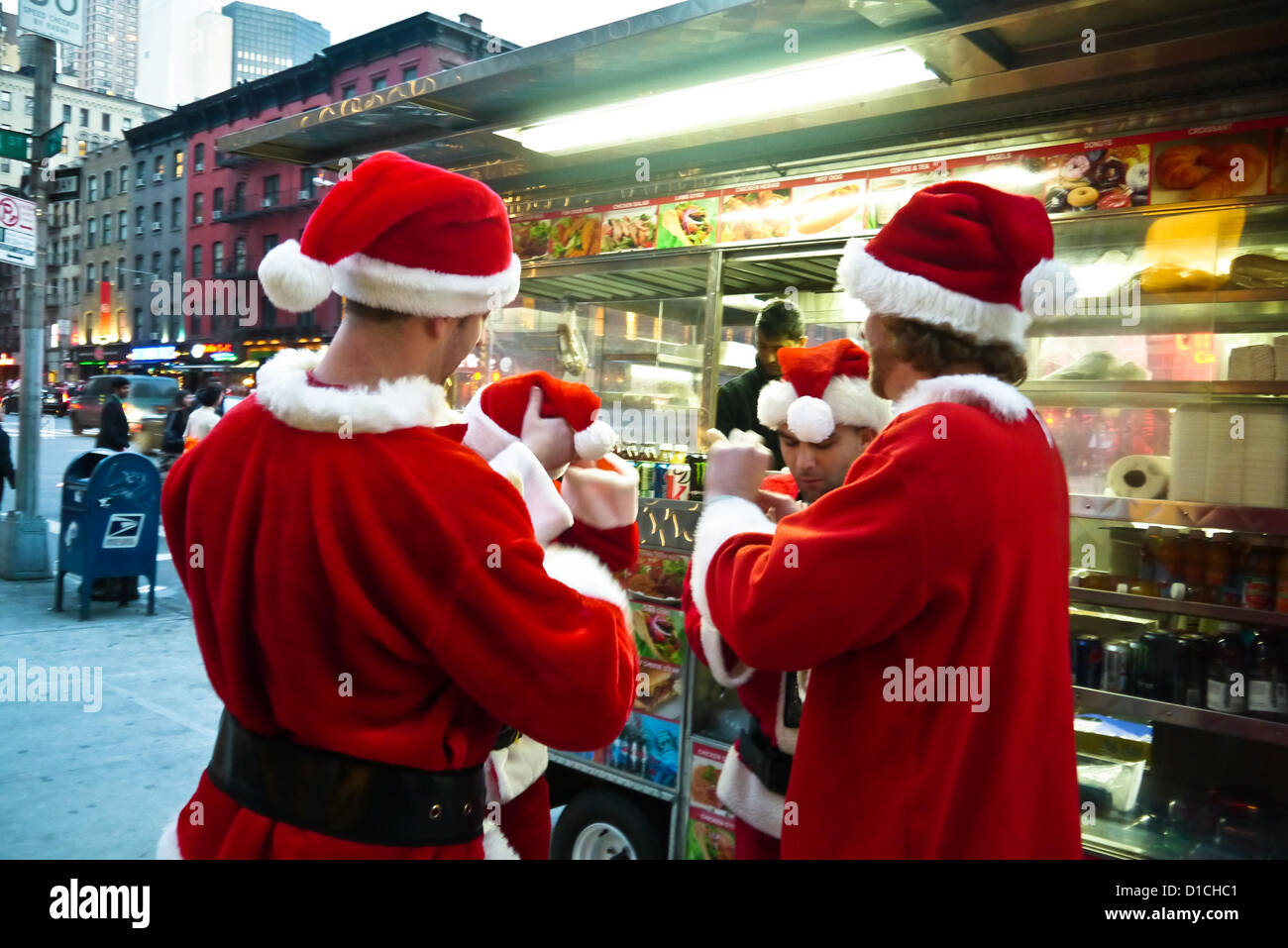 NEW YORK, NY - 15 dicembre: buontemponi vestiti da Babbo Natale da ordinare a un cibo carrello sulla terza avenue durante l'annuale evento SantaCon Dicembre 15, 2012 in New York City. (Foto di Donald Bowers) Foto Stock
