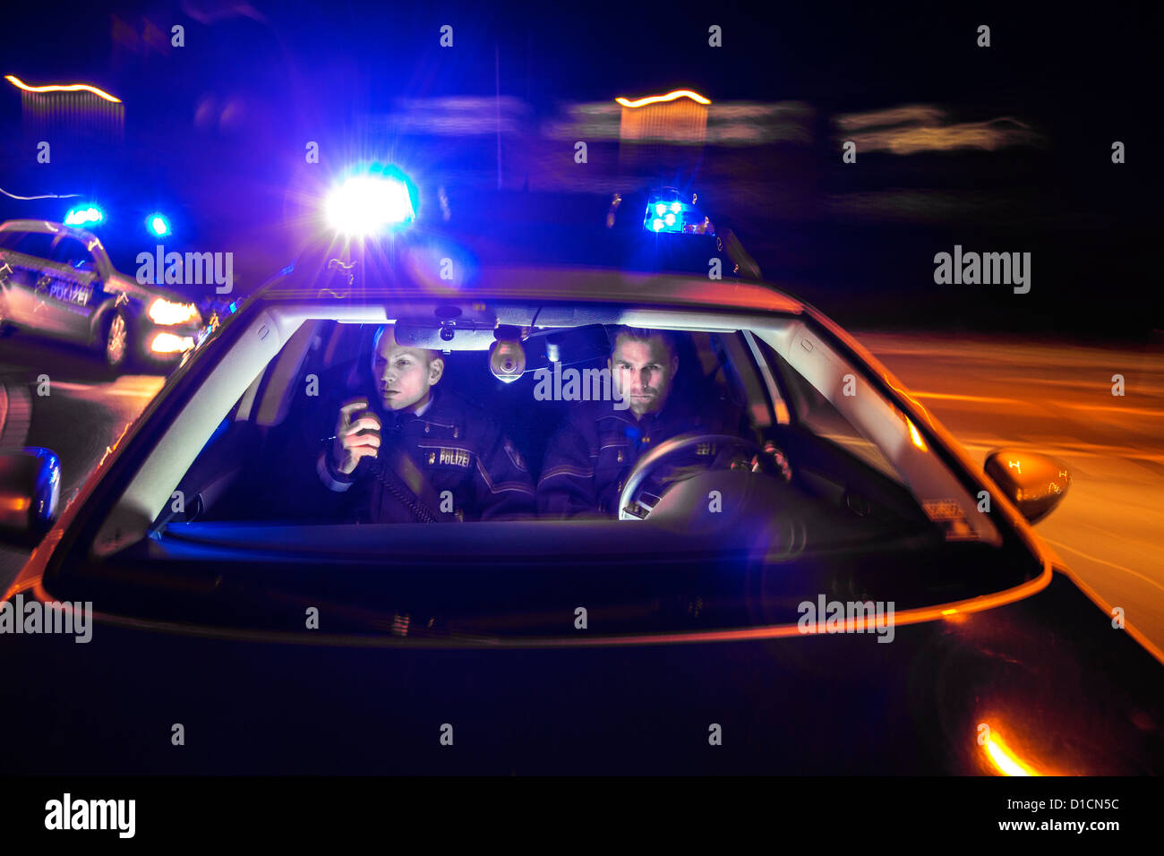 Pattuglia di polizia con luce blu lampeggiante luci, avvisatore acustico, la guida veloce durante una missione di emergenza. Foto Stock