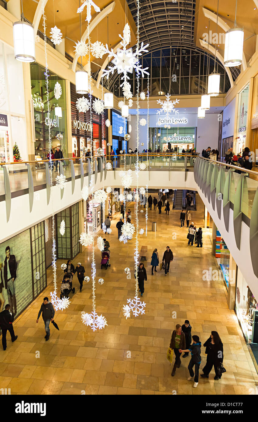 Le decorazioni di Natale e gli acquirenti all'interno di John Lewis shopping centre, Cardiff Wales, Regno Unito Foto Stock