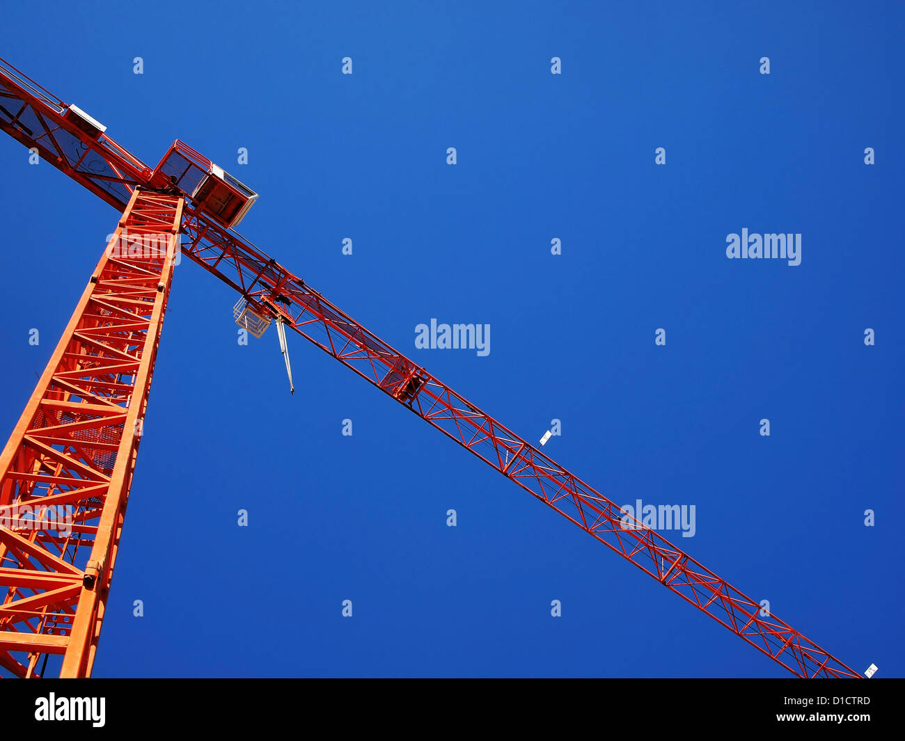 Costruzione arancione gru sul cielo blu sullo sfondo come visto dal di sotto Foto Stock
