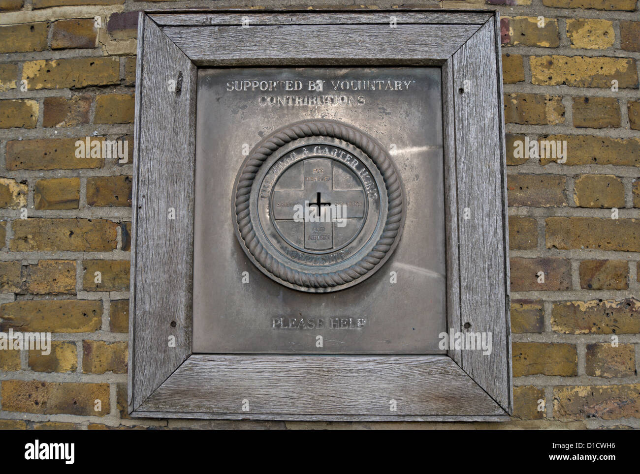 Montato a parete charity box esterno ancaster house, Richmond, Surrey, Inghilterra, invitando le donazioni a stella e garter home Foto Stock
