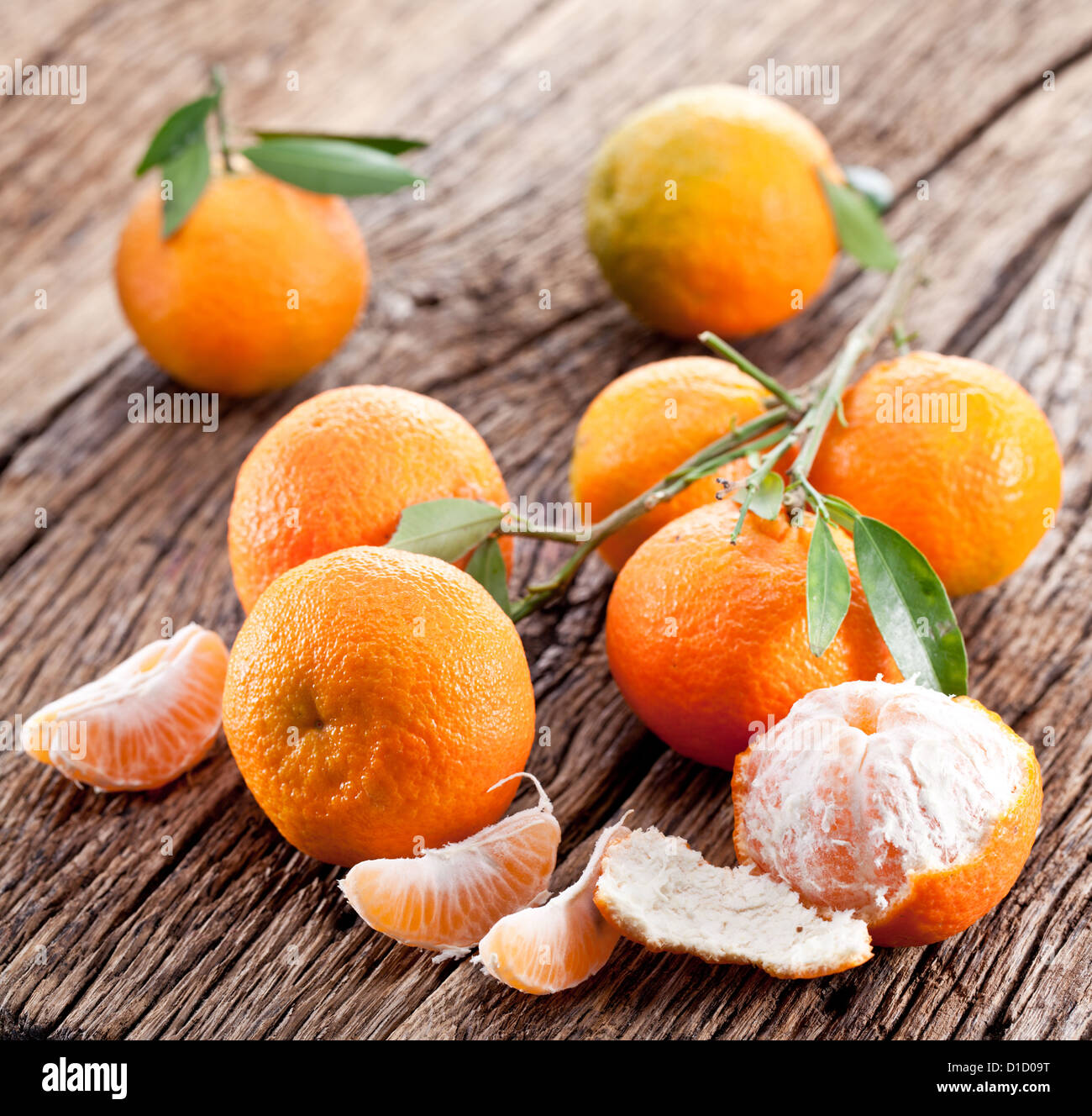 Tangerini con foglie su un tavolo di legno. Foto Stock