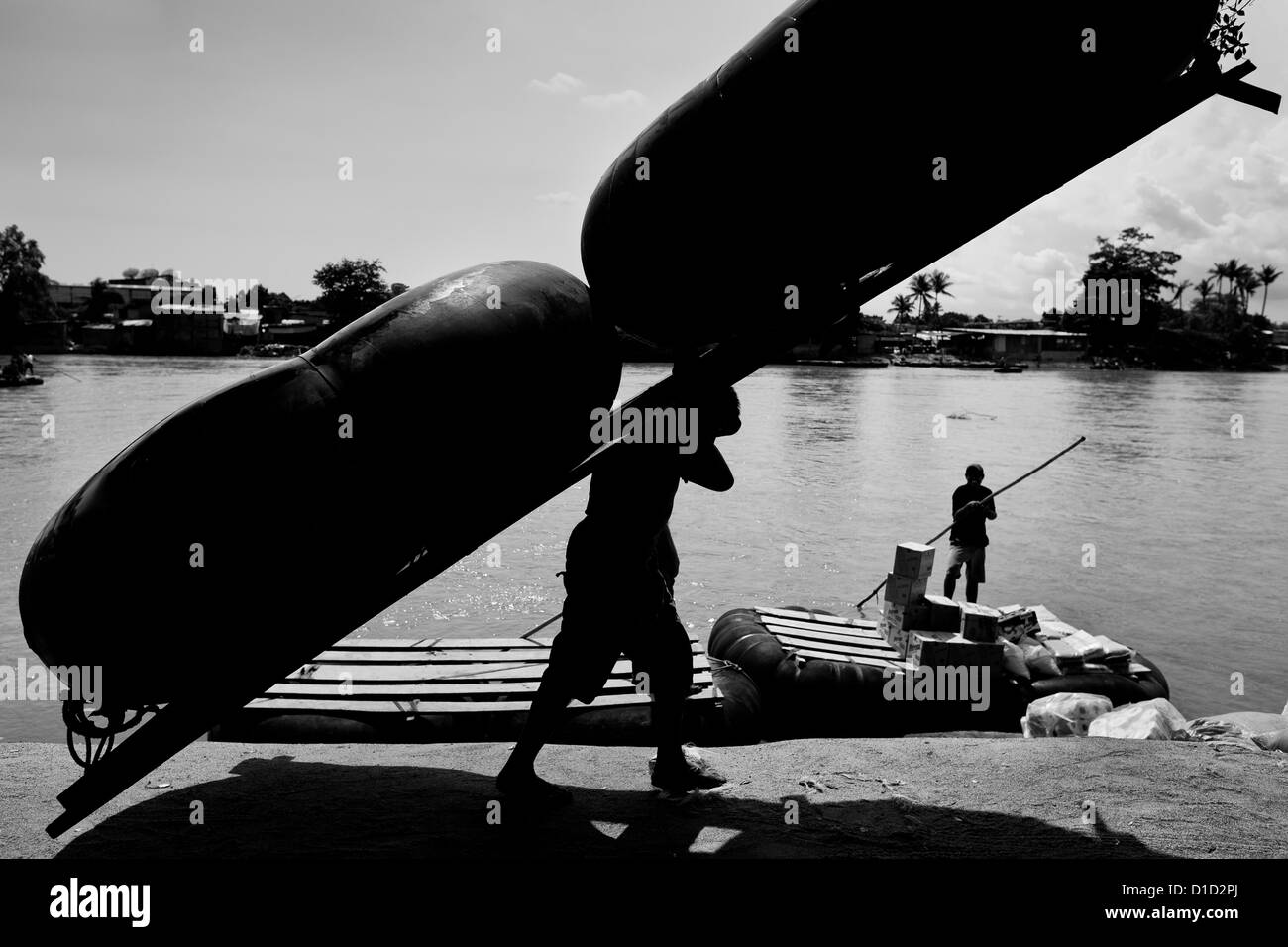 Un barcaiolo guatemalteco trasporta un ripiego tubo interno zattera sulla banca del fiume suchiate in Tecún Umán, guatemala. Foto Stock