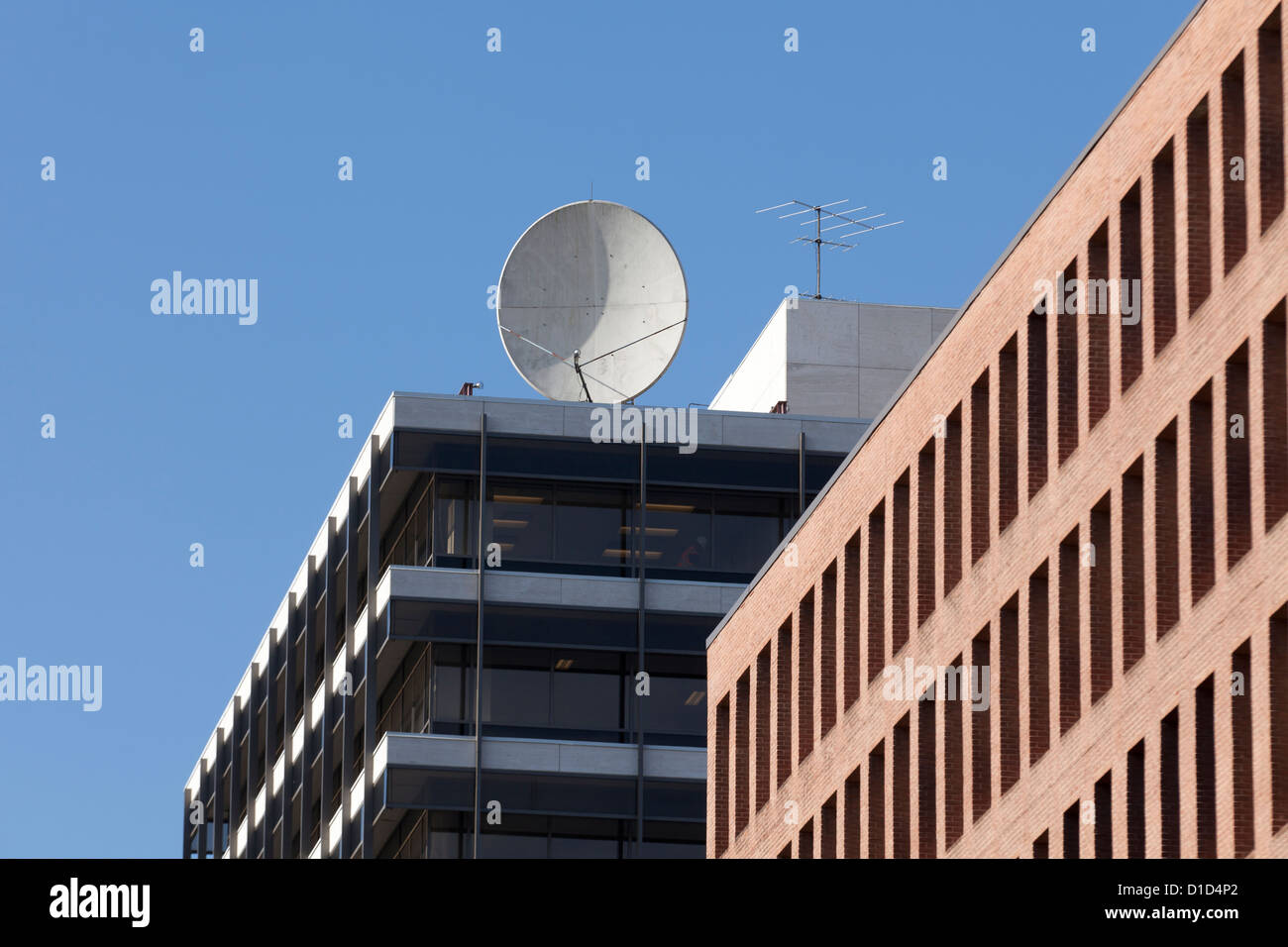 Satellite di comunicazioni piatto sulla parte superiore della costruzione Foto Stock