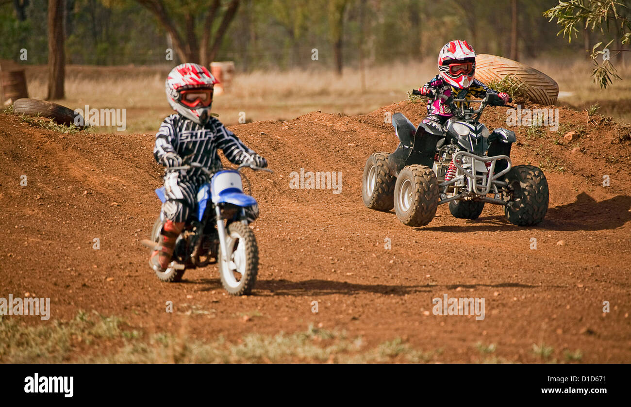 I ragazzi di indossare abbigliamento protettivo e caschi in sella a una  moto quad e moto sulla pista sterrata in Australia Foto stock - Alamy