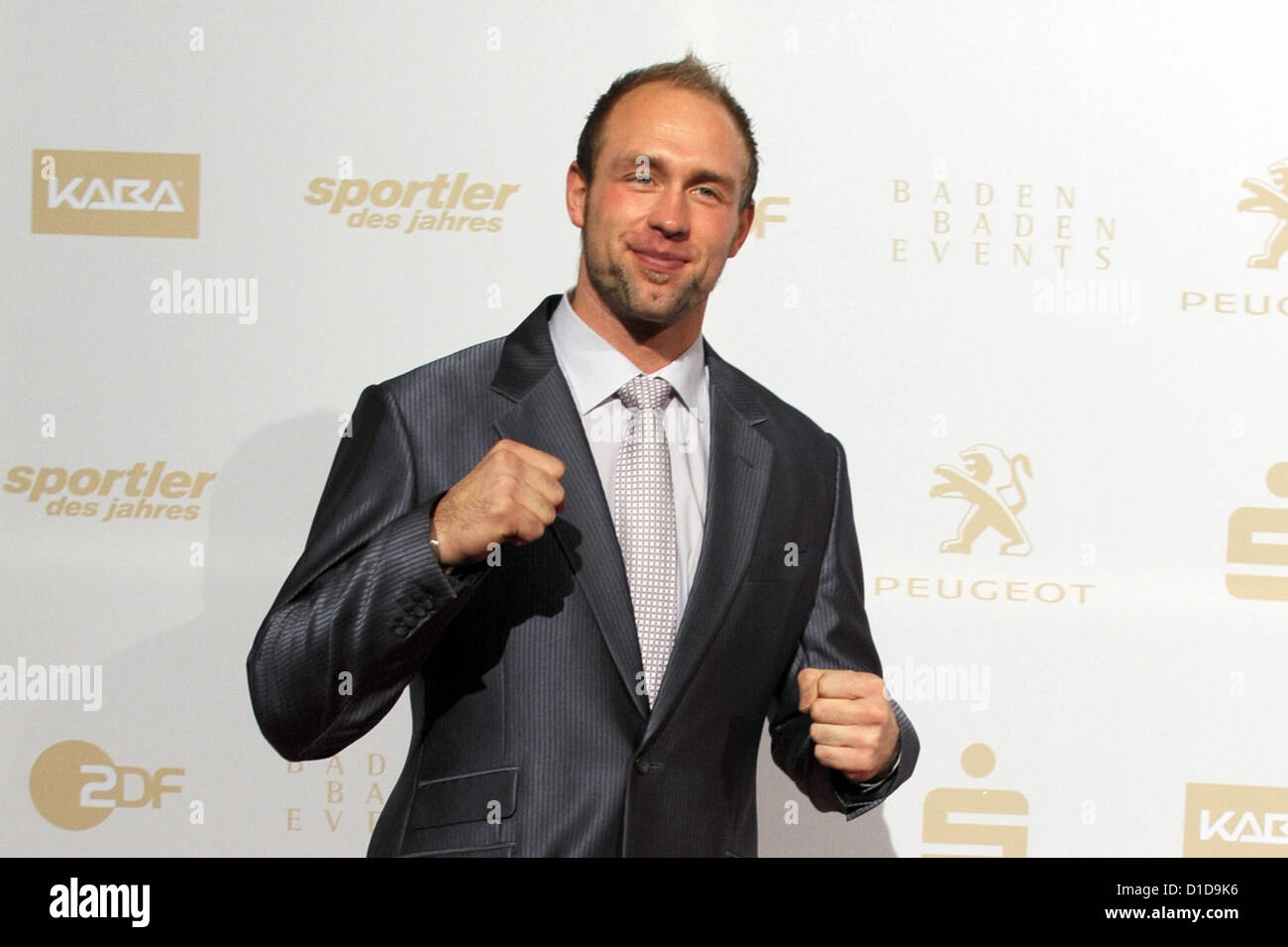 Discus thrower Robert Harting sorge sul tappeto rosso in arrivo per i premi mostra 'Sportler des Jahres 2012' (atleta dell'anno 2012) presso il Kurhaus venue a Baden-Baden, Germania, 16 dicembre 2012. Foto: Patrick Seeger Foto Stock