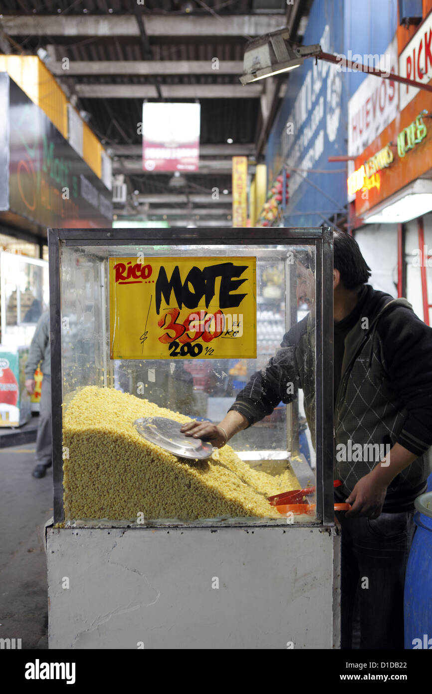 Titolare di stallo serve un cliente chicchi di grano (mote) utilizzati nella pesca drink in La Vega Mercato, Santiago del Cile, Sud America Foto Stock