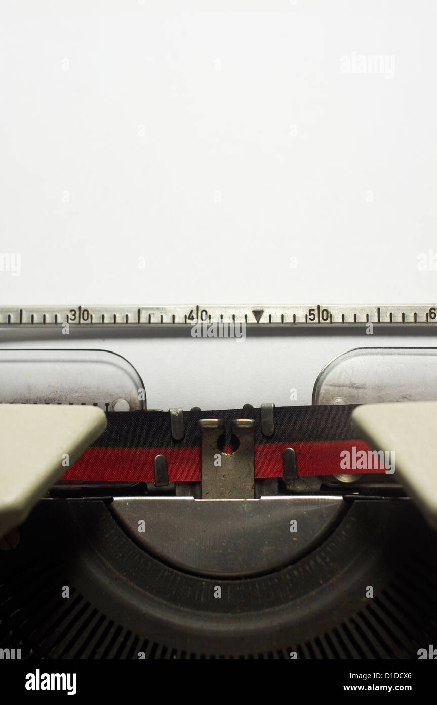 Una chiusura di una macchina da scrivere, la messa a fuoco su un foglio di carta in cui il messaggio verrà digitata. Foto Stock