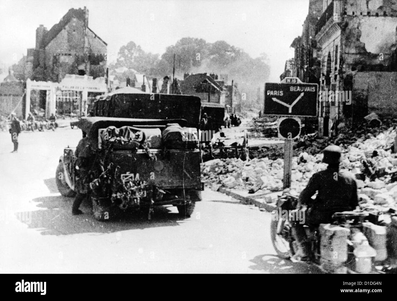 Le truppe tedesche marciano lungo città francesi distrutte sulla loro strada per invadere Parigi nel giugno 1940. Luogo sconosciuto. Fotoarchiv für Zeitgeschichte Foto Stock