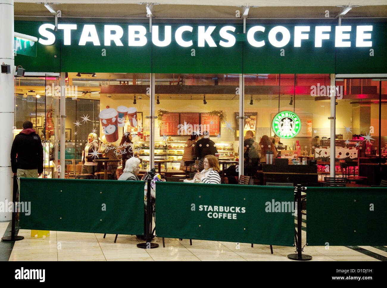 Le persone che bevono alla Starbucks Coffee bar, il centro di MK Milton Keynes, Buckinghamshire REGNO UNITO Foto Stock