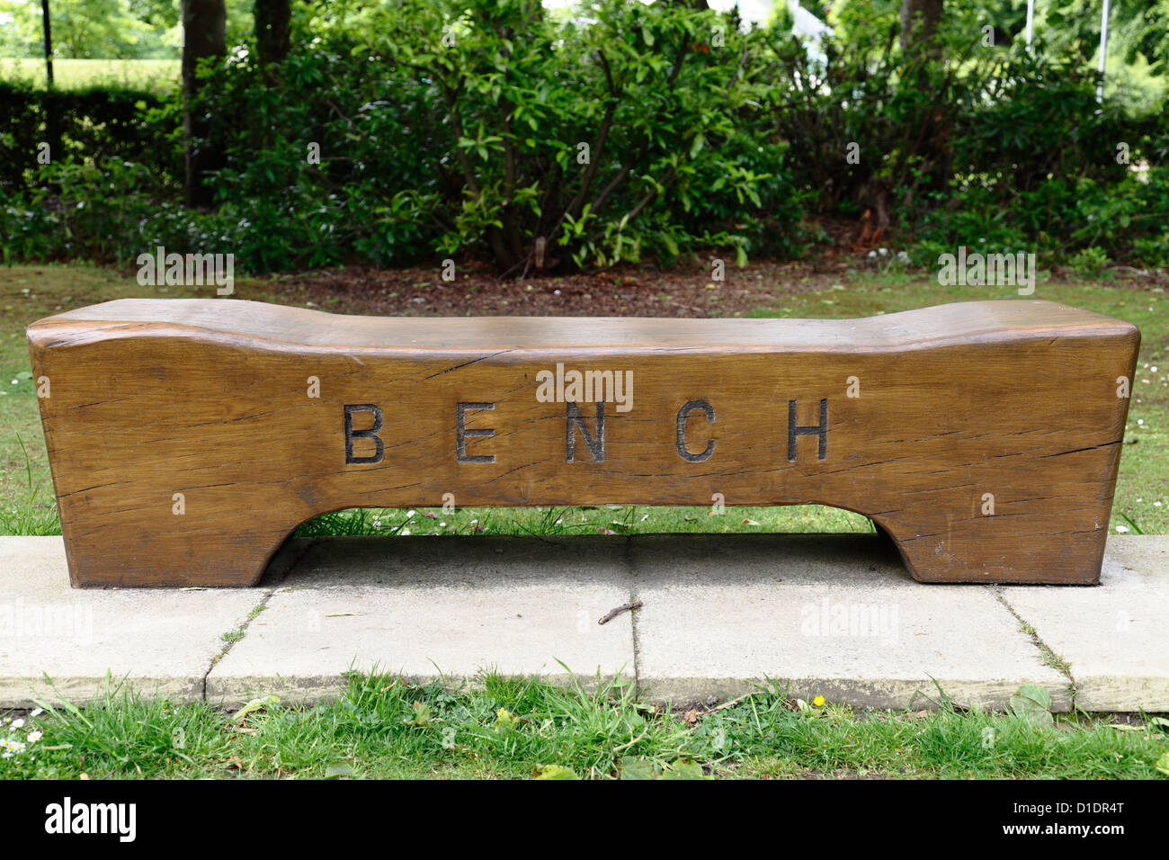 Una panchina vuota del parco in legno con la panca di parola scolpita sulla parte anteriore nel Bellahouton Park a Glasgow, Scozia, Regno Unito Foto Stock