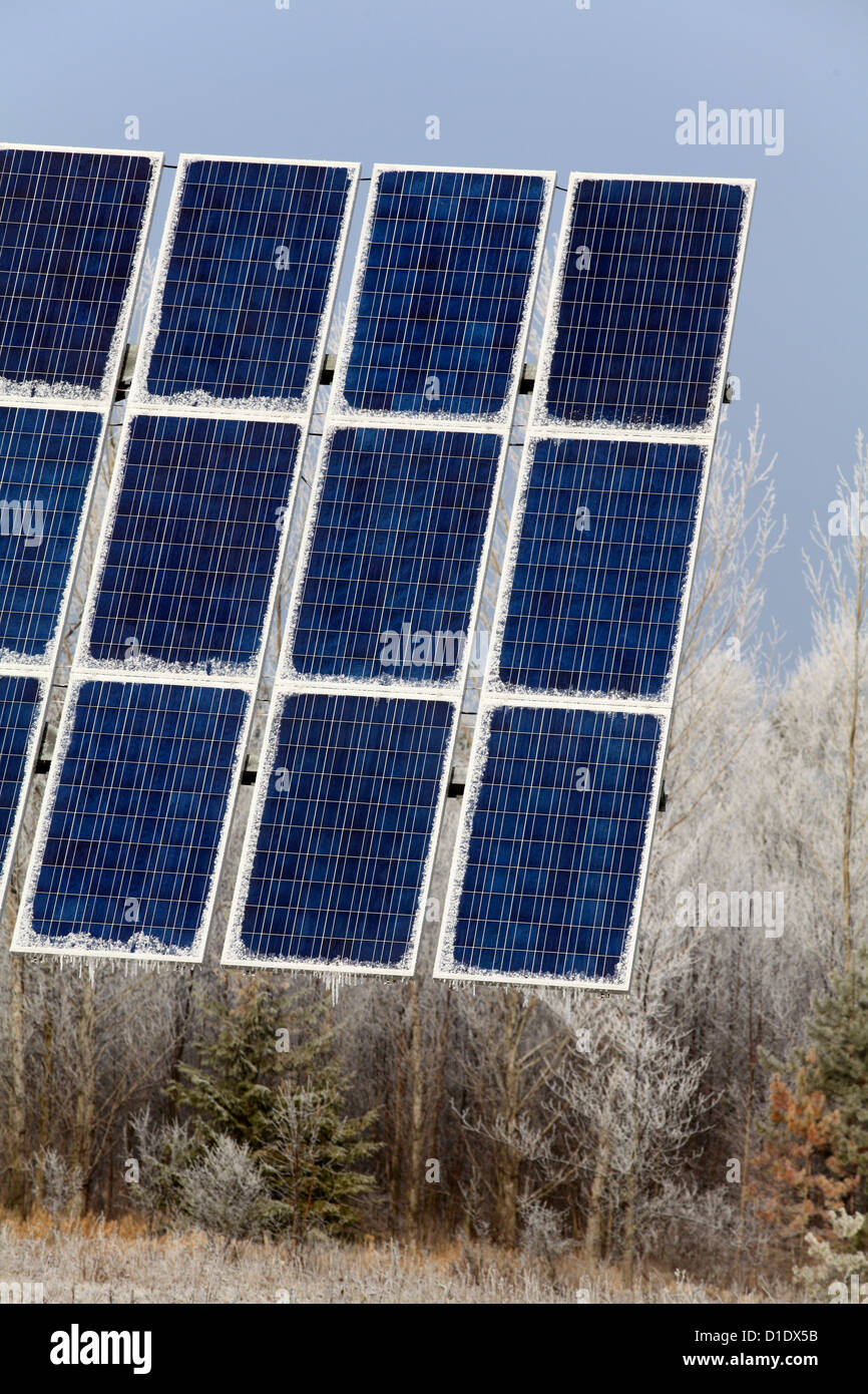Grandi pannelli solari con gelo invernale e ghiaccioli appeso, energia alternativa, scelta ambientale, Foto Stock