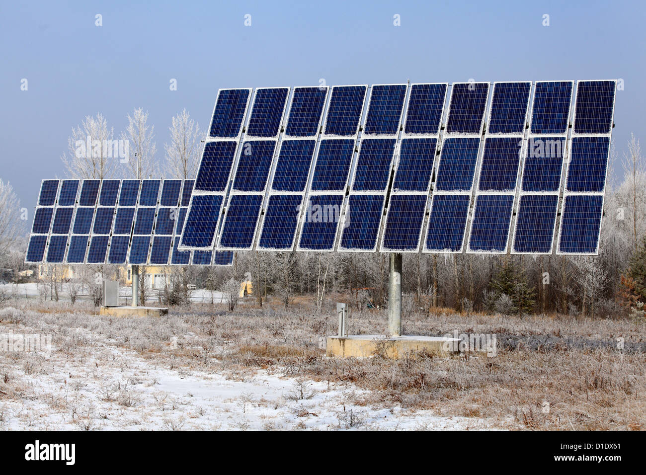 Grandi pannelli solari con gelo invernale e ghiaccioli appeso, energia alternativa, scelta ambientale, Foto Stock