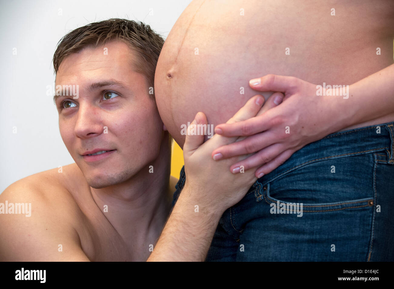 Un simbolico non datata immagine mostra un giovane uomo di intercettazioni attraverso il ventre di sua moglie incinta. Foto: Hans Wiedl - Modello rilasciato Foto Stock