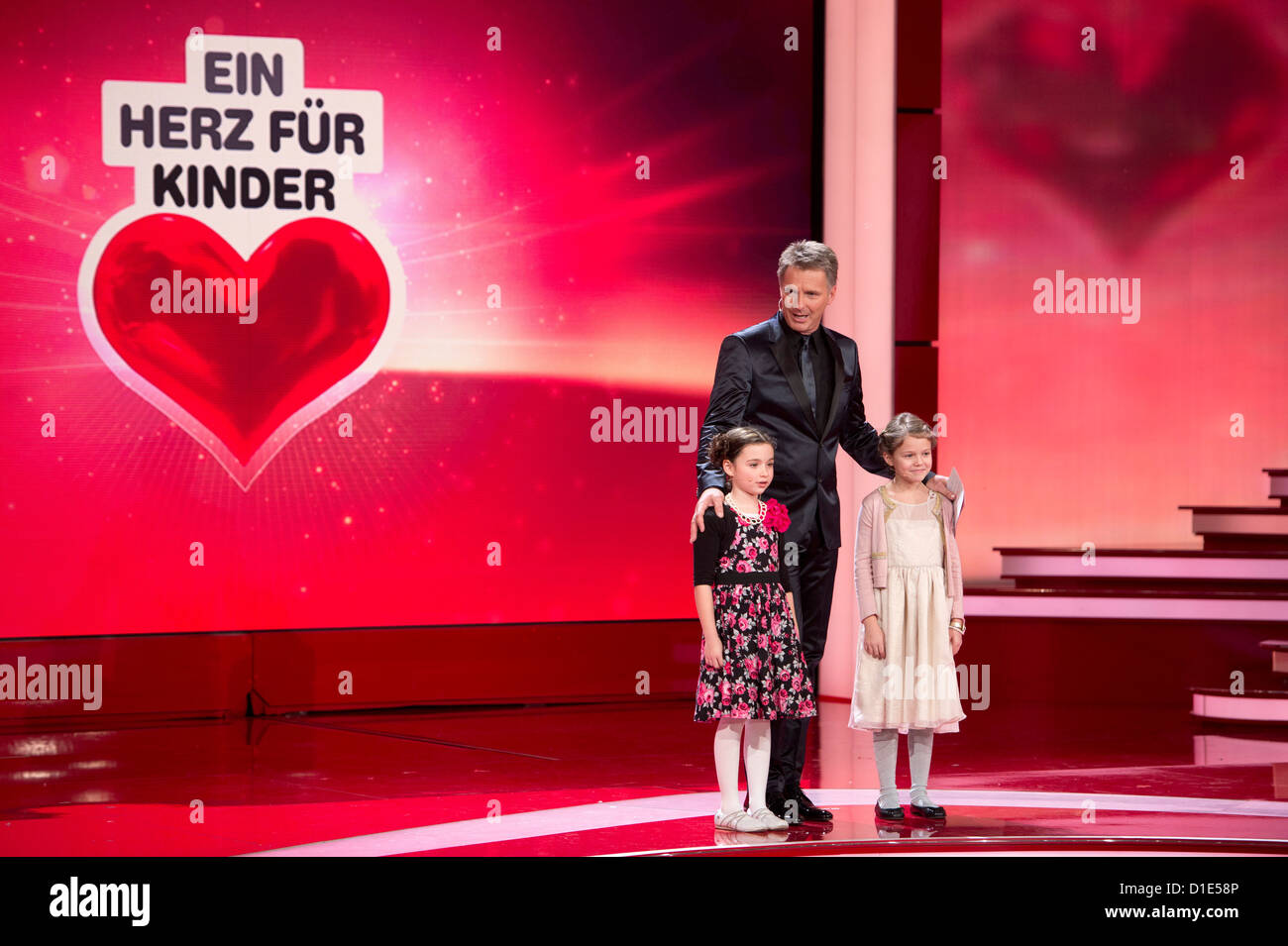 Moderatore Jörg Pilawa steht am Samstag (15.12.12) in Berlin bei der Livesendung "Ein Herz für Kinder' mit Kindern auf der Bühne. Die Gala wird im ZDF übertragen. Foto: Axel Schmidt dpa Foto Stock
