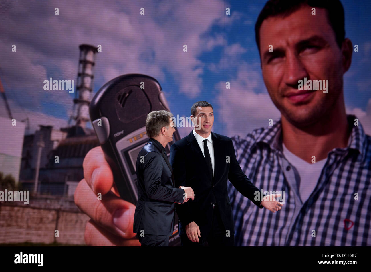 Moderatore Jörg Pilawa und der ukrainische Profiboxer Wladimir Klitschko unterhalten sich am 15.12.2012 in Berlin bei der Livesendung "Ein Herz für Kinder', während im Hintergrund Bilder gezeigt werden, die während eines Besuchs von Klitschko in Tschernobyl (Ucraina) nahe der Stätte des Reaktorunglücks von 1986 aufgenommen wurden. Die Gala wird im ZDF übertragen. Foto: Axel Schmidt dpa Foto Stock