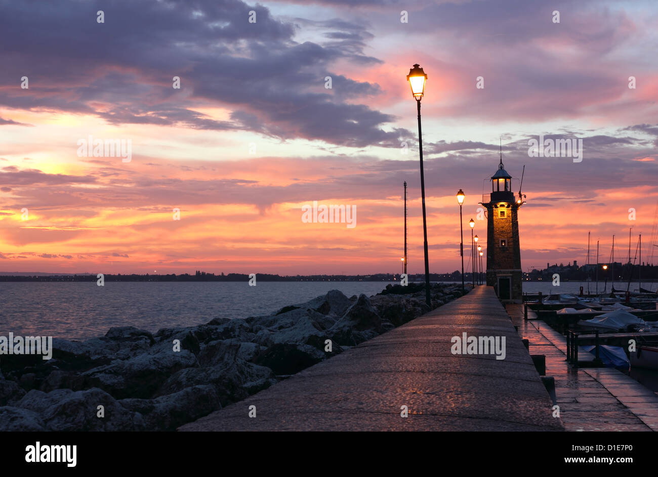 Incredibile Sunrise a Desenzano del Garda con il porto turistico e il vecchio faro. Foto Stock