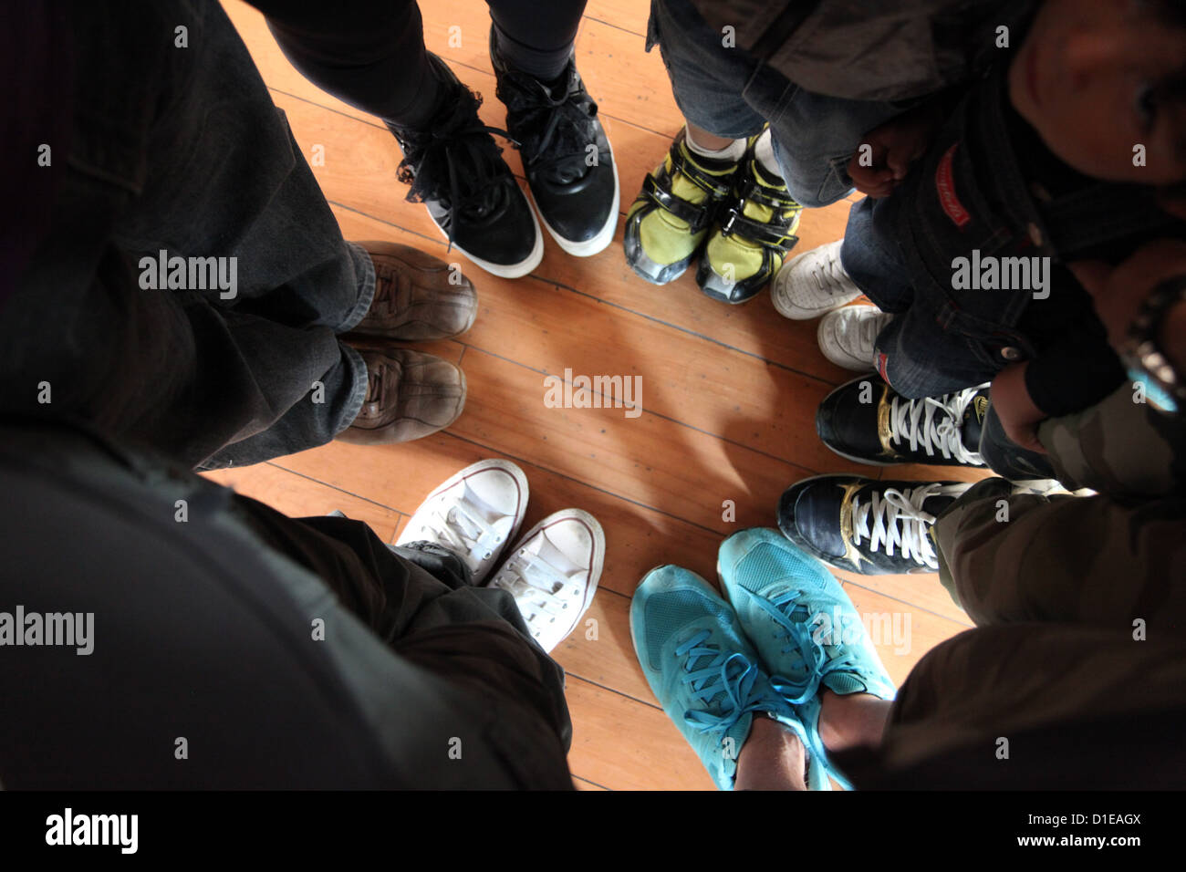 Si tratta di una foto vista dalla cima di molte persone a mettere i loro piedi a fianco a fianco in cerchio per mostrare le loro scarpe. Si tratta di creative Foto Stock