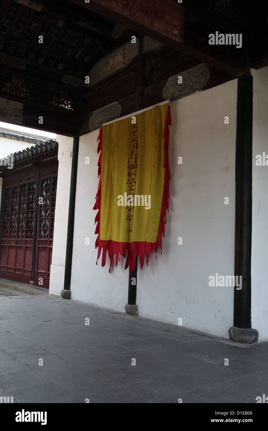 Si tratta di una foto di un corridoio in un tempio cinese vicino a Shanghai. Non vi è nessuno. possiamo vedere una bandiera gialla contro il muro. Colonna Foto Stock