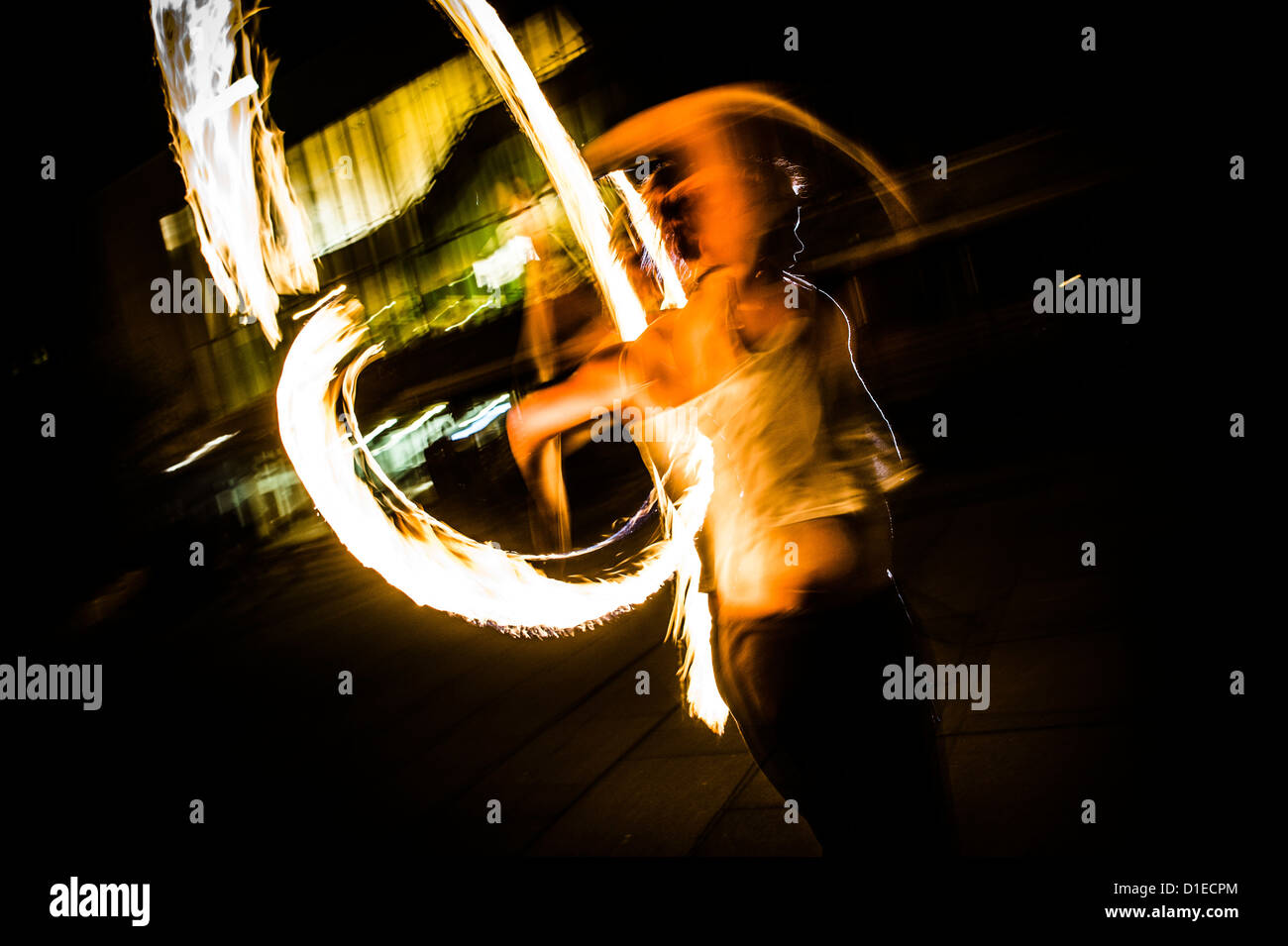 Una giovane donna ballare con il fuoco poi di notte. Regno Unito Foto Stock