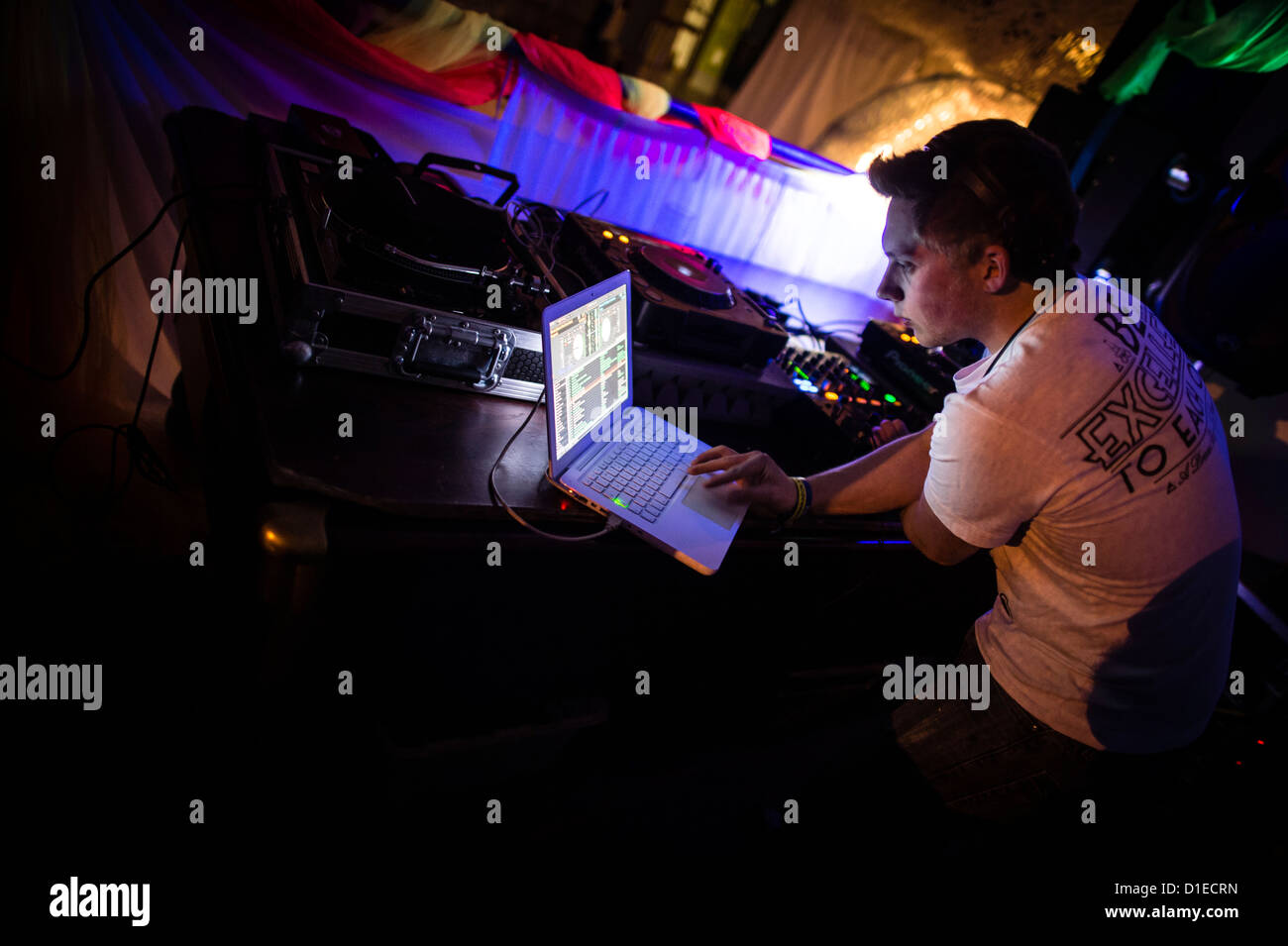 Un DJ allineando la musica sul suo computer portatile per la riproduzione a una festa da ballo rave discoteca notte , REGNO UNITO Foto Stock