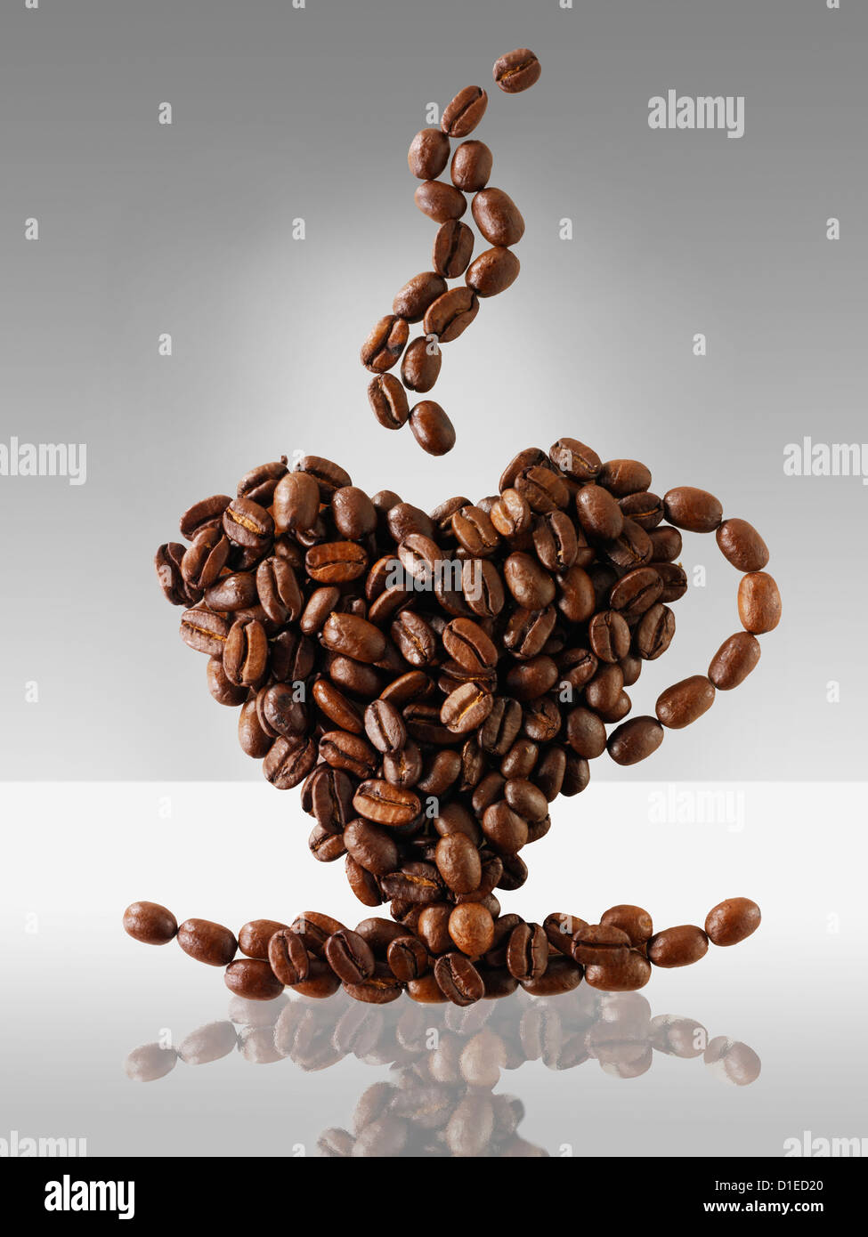 I chicchi di caffè facendo la forma di una fumante tazza di caffè. Foto Stock