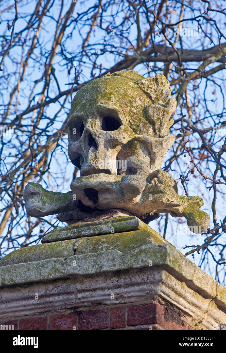 Londra, Deptford uno dei due del XVII secolo il cranio e crossbone incisioni sul cancello principale di St Nicholas' chiesa Foto Stock