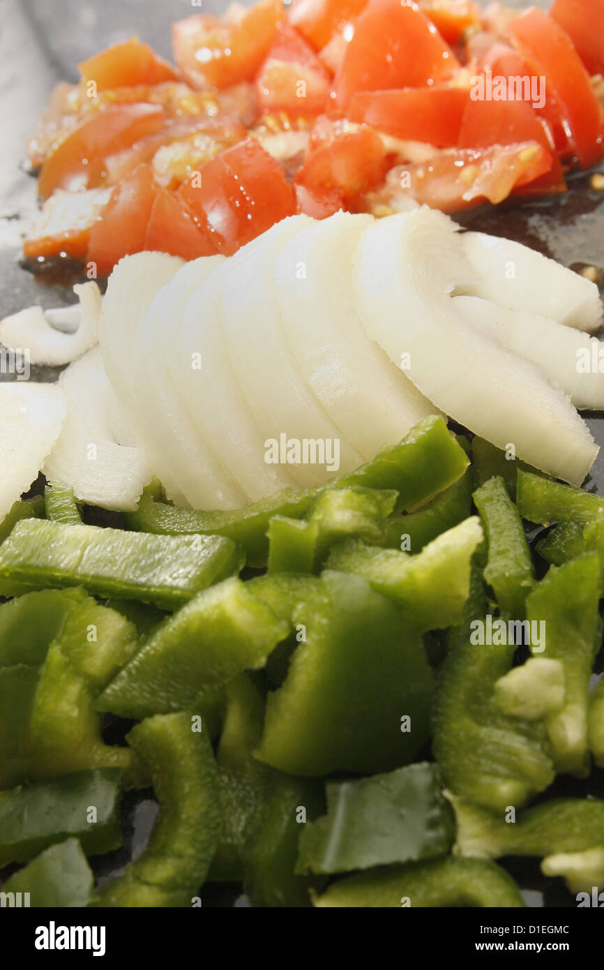 Un trito di peperoni verdi, pomodori e cipolle bianche sul marmo tagliere Foto Stock