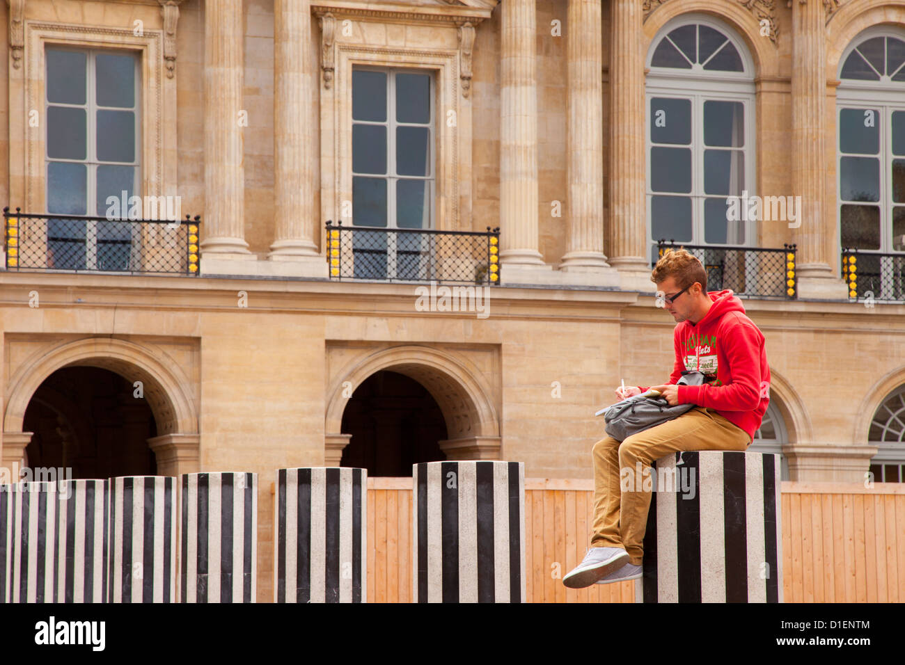 Art Student creazione di un disegno dalla cima di uno di Daniel Buren le colonne all'interno di Palais Royal, Paris Francia Foto Stock