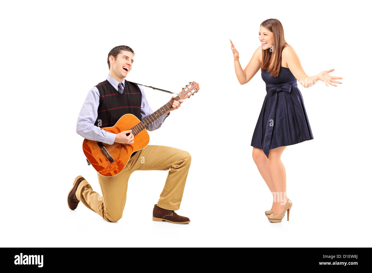 Un maschio di giocare su una chitarra e canto alla sua ragazza isolata contro uno sfondo bianco Foto Stock
