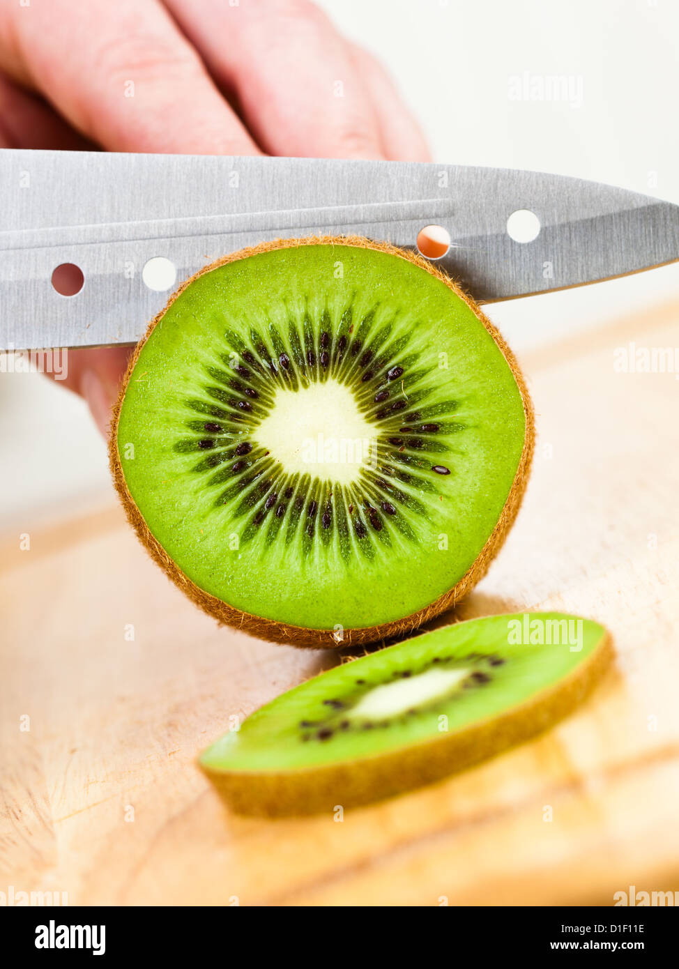 Donna taglio mani fresche Kiwi in cucina Foto Stock