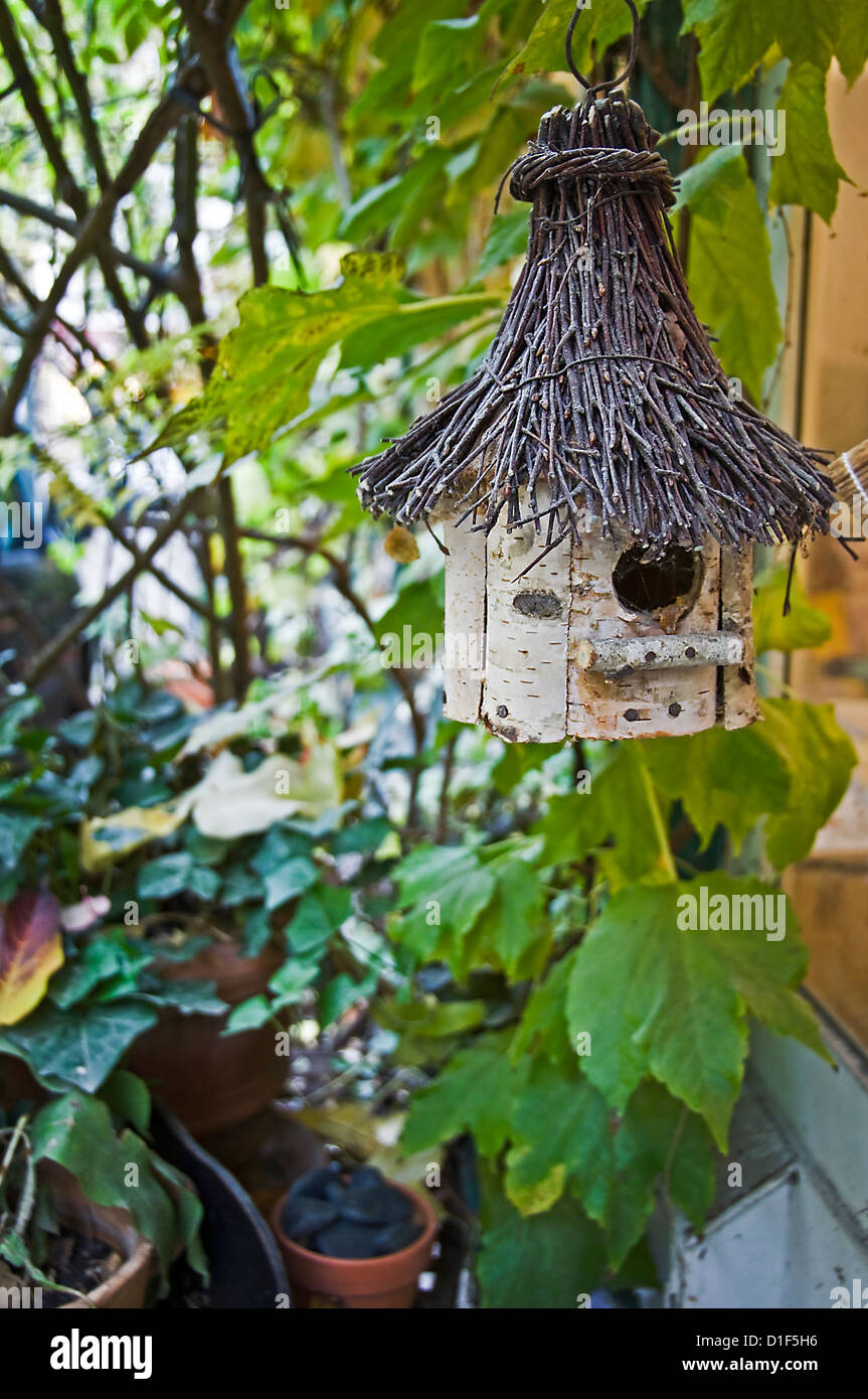 Rifugio di uccelli e il presepe in legno appesa in un giardino Foto Stock