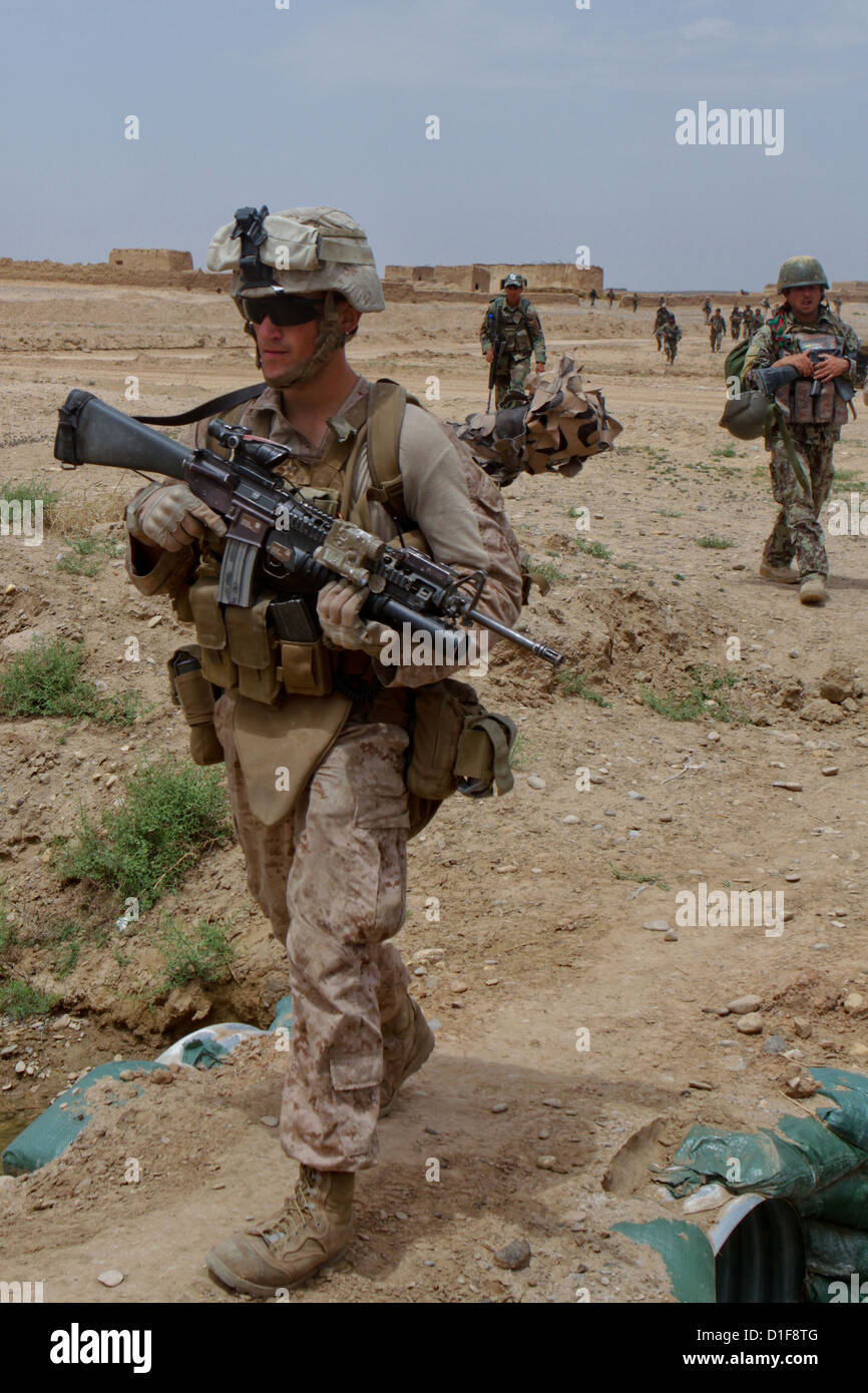 Un marine statunitense di pattuglie con il suo esercito nazionale afghano omologhi 26 aprile 2012 intorno Trek Nawa, Afghanistan. La Afghan-funzionamento led cancellata composti e cercato di ordigni esplosivi rudimentali armi e memorizza nella cache. Foto Stock
