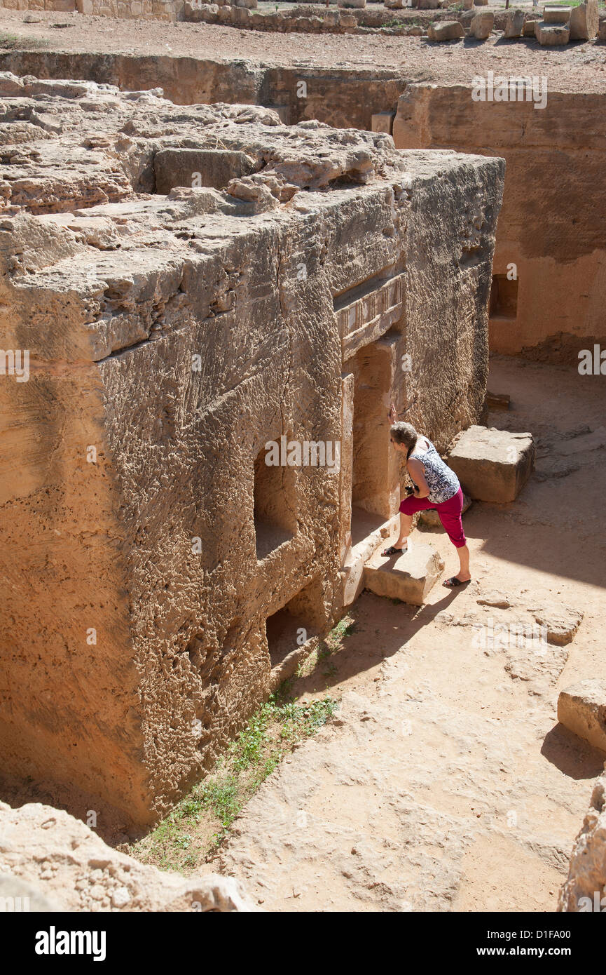 Tombe dei Re una grande attrazione archeologica in Paphos Cipro turista femminile guardando all'interno Foto Stock