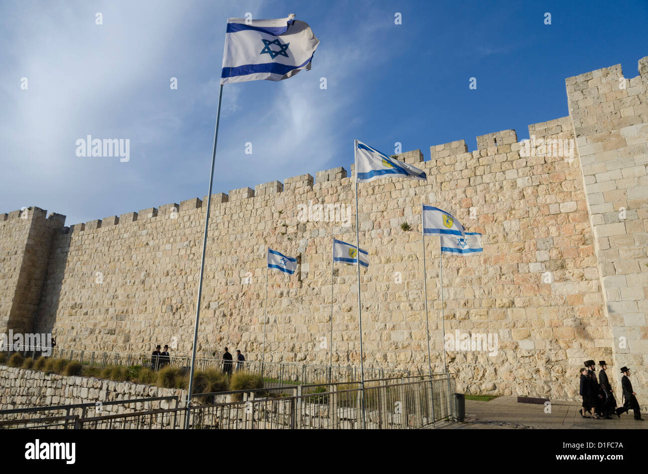 Vista delle mura della città con gli Ebrei Ortodossi e bandiera Israeliana. La città vecchia di Gerusalemme, Israele, Medio Oriente Foto Stock