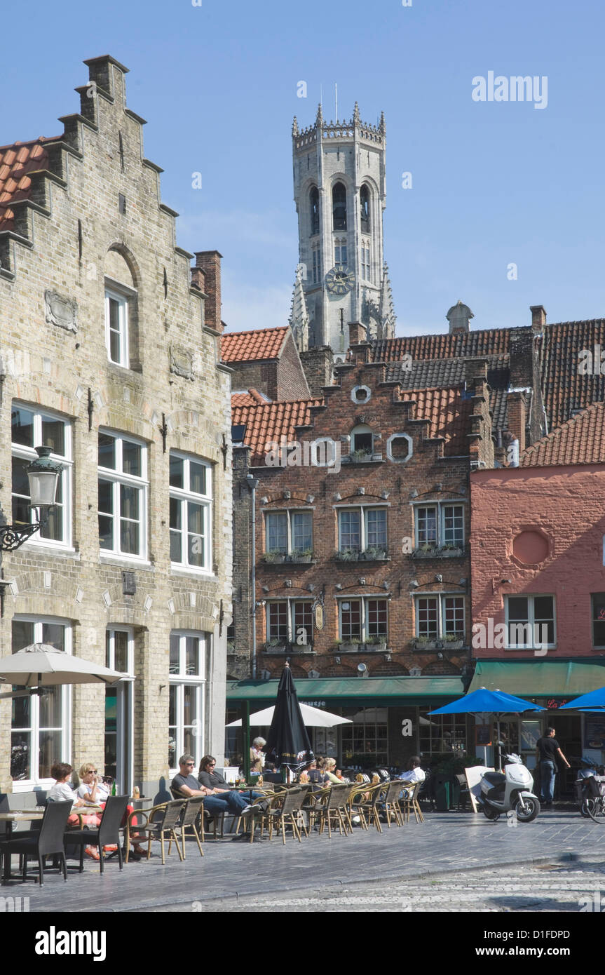 Fiammingo a gradini gables over street cafe con il campanile da piazza del mercato dietro, Brugge, Belgio, Europa Foto Stock