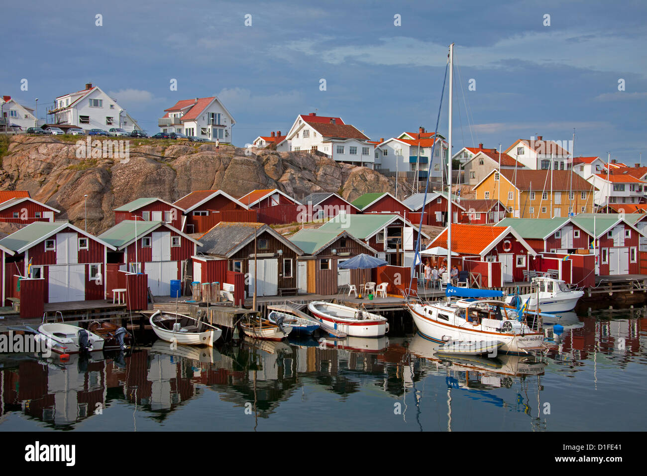 Colorate di pesca tradizionali capanne e boathouses con barche lungo il molo in legno a Smögen, Bohuslän, Svezia e Scandinavia Foto Stock