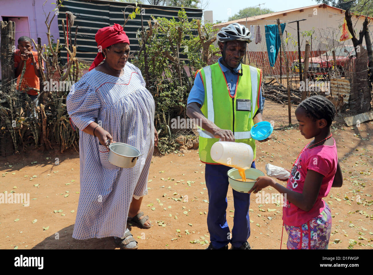 Un volontario dei Leoni del Centro di cura ONG in Tsumeb/Namibia porta la zuppa ai poveri di una cittadina Foto Stock