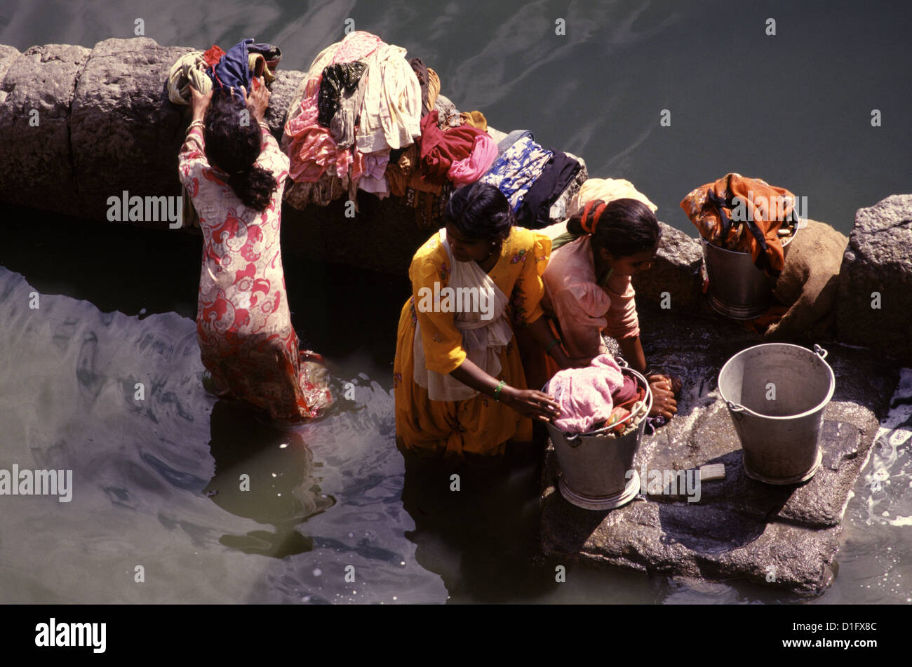 Le donne lavano il bucato alla riva del lago di Agastya (Ththa) in Badami situato nel distretto di Bagalkot di Karnataka, India Foto Stock