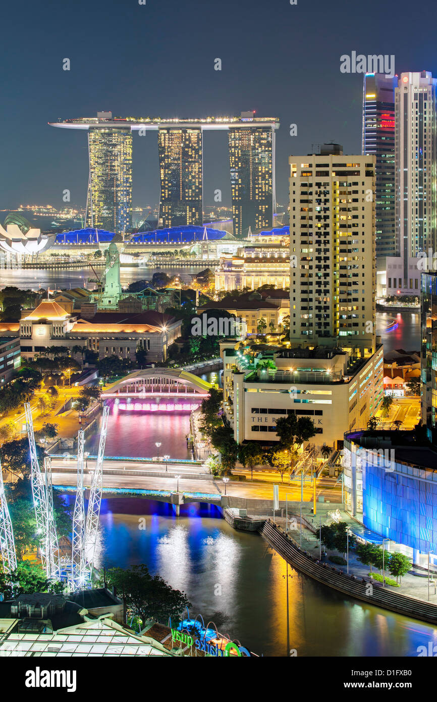 Vista in elevazione sopra il quartiere degli intrattenimenti di Clarke Quay, il Fiume Singapore e dello skyline della città di notte, Singapore Foto Stock